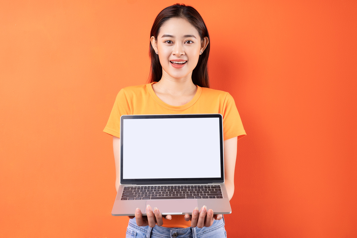 Young Asian Woman Holding Laptop with Empty Screen